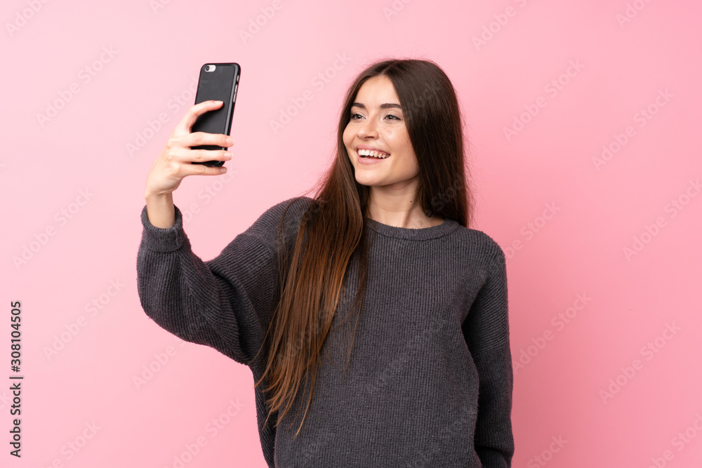 Young woman over isolated pink background making a selfie Young woman over isolated pink background making a selfie