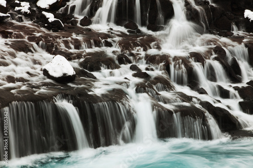 Hraunfossar is a series of waterfalls formed by rivulets streaming over a distance of about 900 metres out of the Hallmundarhraun, a lava field which flowed from an eruption.
