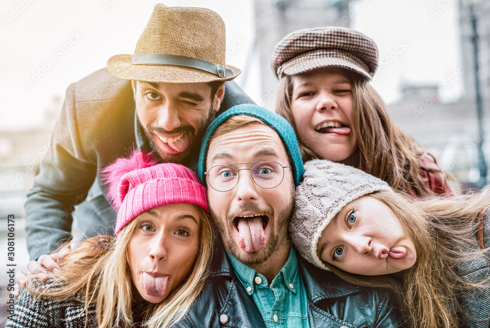 Best friends taking selfie on winter fashion clothes - Happy friendship concept with millennial people having fun together - Everyday life of next generation guys and girls enjoying holidays lifestyle