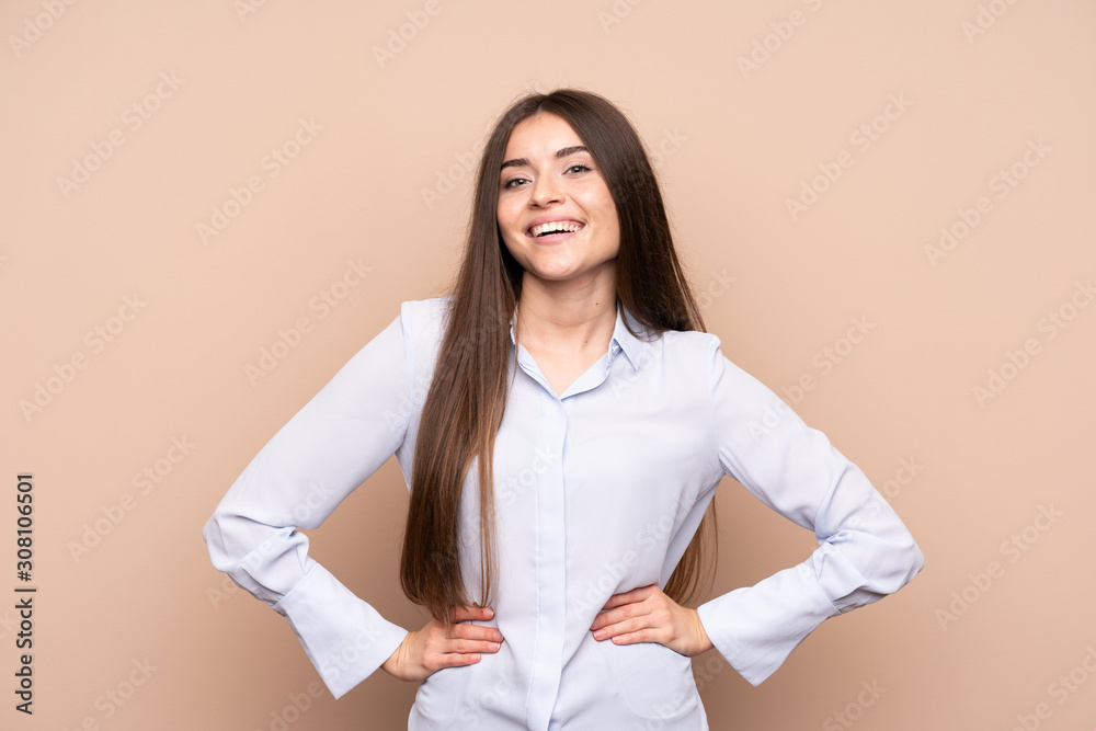 Young woman over isolated background posing with arms at hip and smiling Young woman over isolated background posing with arms at hip and smiling