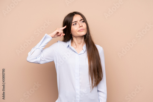 Young woman over isolated background making the gesture of madness putting finger on the head