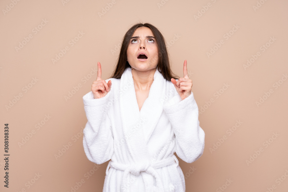 Young girl in a bathrobe over isolated background pointing with the index finger a great idea Young girl in a bathrobe over isolated background pointing with the index finger a great idea