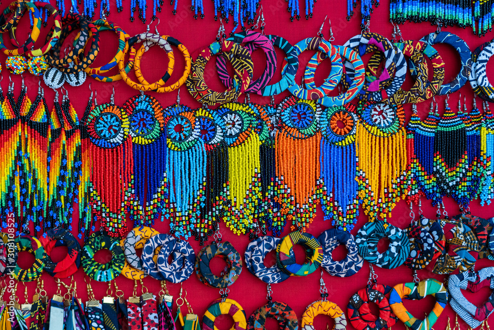 Fototapeta premium Tribal masai colorful earrings for sale for tourists at the beach market, close up. Island of Zanzibar, Tanzania, Africa
