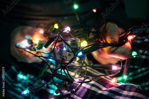 Man trying to untangle Christmas lights