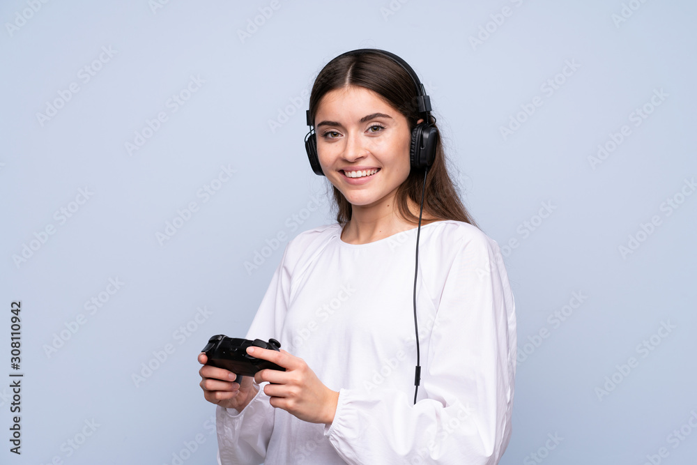 Young woman over isolated blue background playing at videogames Young woman over isolated blue background playing at videogames