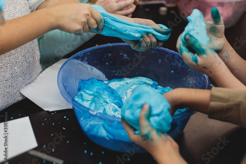 Group of kids making a multicoloured slime, pink, blue and white slime toy on kids birthday party, kid playing with slime, homemade slime