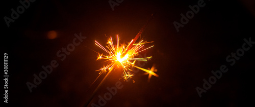 Sparklers for Christmas and New Year close-up in the form of a banner and on a black background