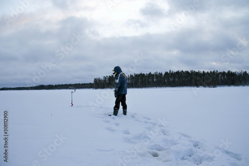 Russia.Karelia.Man holding a winter fishing rod.December.2019.