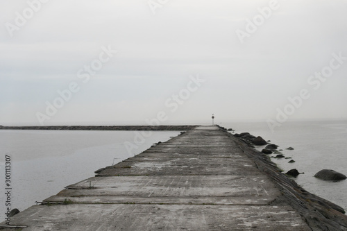 Stone pier on the sea in the rain