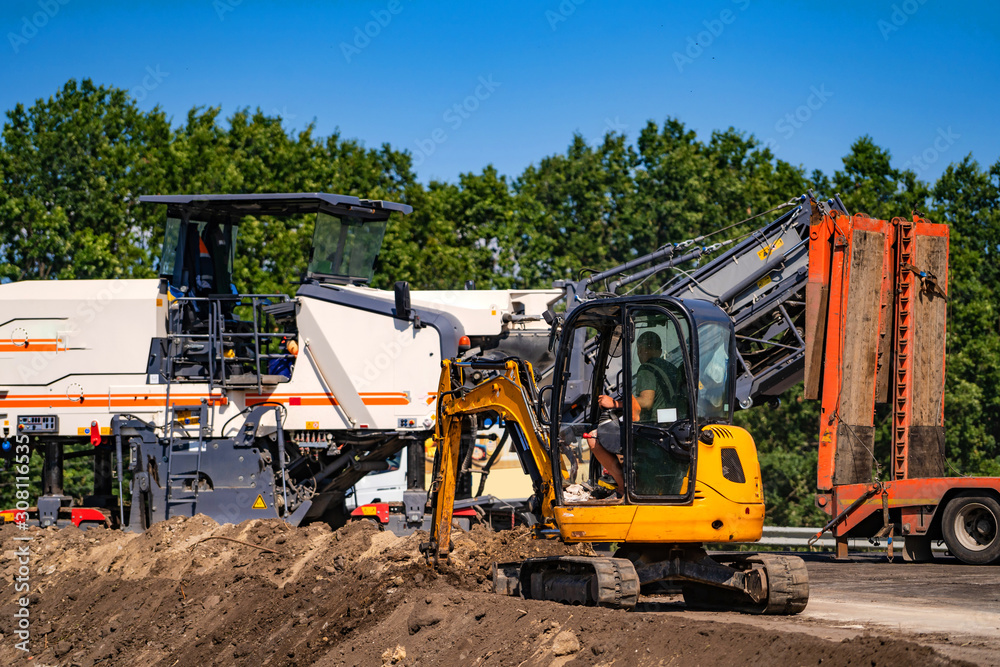Road construction with working commercial equipment. Heavy machinery on road repair. Road construction with working commercial equipment. Heavy machinery on road repair.