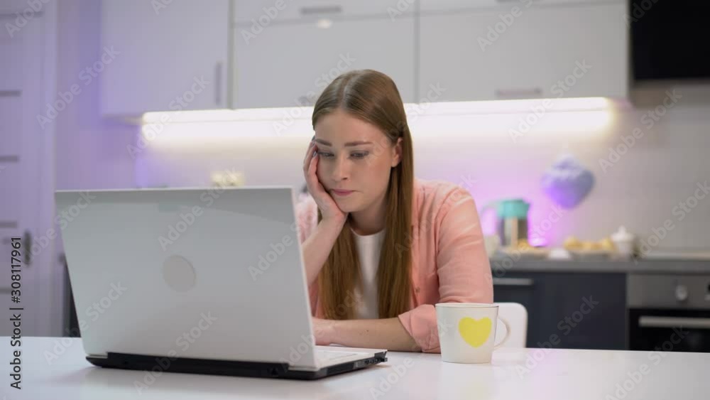 Concentrated young woman typing on laptop, working at home, blogger, occupation