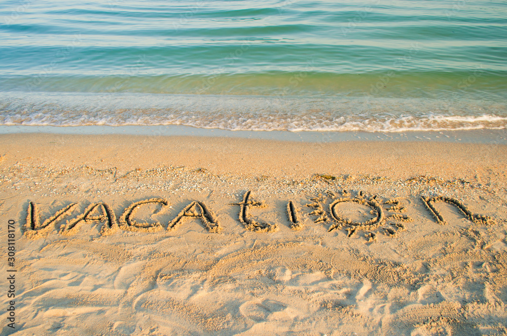 Fototapeta premium The inscription vacation on sand. Shooting on the beach. 