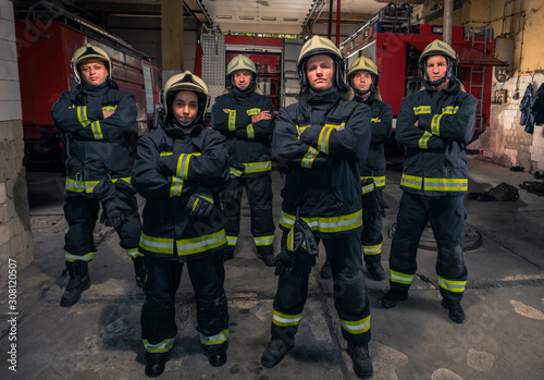 Group of firefighters standing confident with arms crossed. Firemen ready for emergency service. © qunica.com