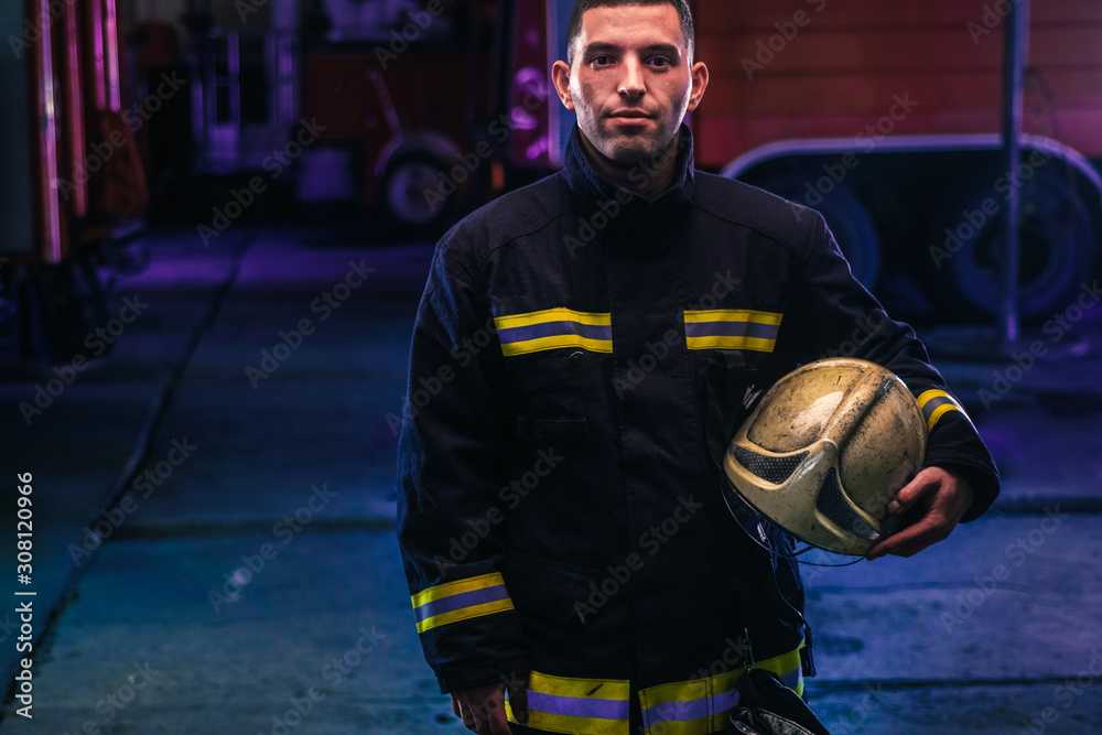 Portrait of a firefighter with uniform inside the fire station Portrait of a firefighter with uniform inside the fire station