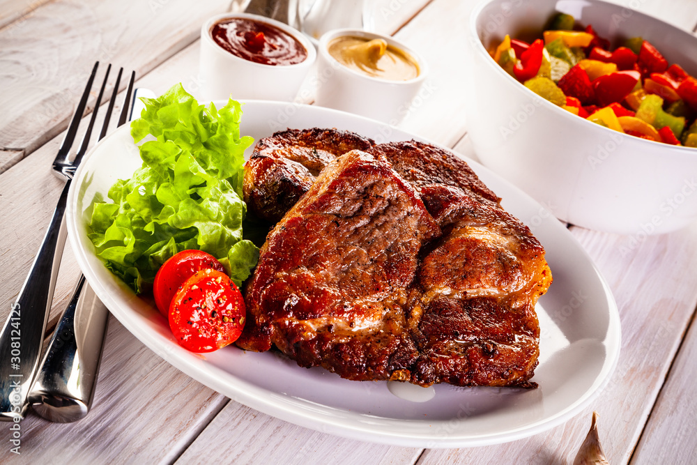 Grilled steak and vegetables on wooden background Grilled steak and vegetables on wooden background
