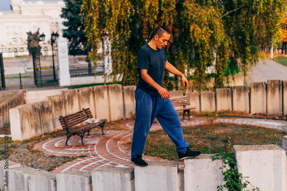 Strong,young man jump high while doing parkour exercise on open sky in a urban area. Strong,young man jump high while doing parkour exercise on open sky in a urban area.