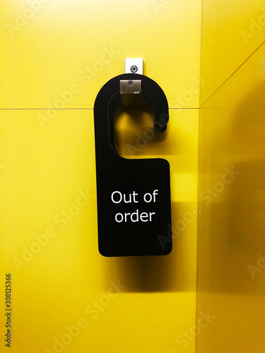 out of order sign on a yellow wall 
