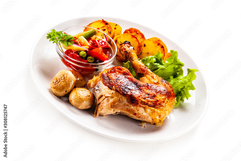 Barbecued chicken leg with chips and vegetables on white background