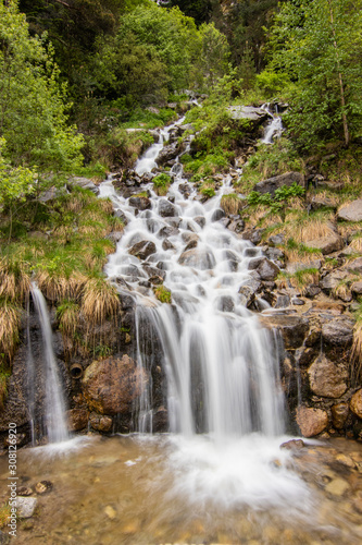 A small cascade waterfall  near a village of Encamp  Andorra. Located in the Pyrenees mountain