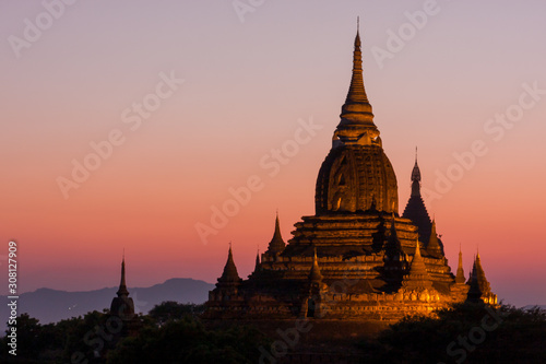 View on multiple pagoda during sunset, bathed in golden light and with some mountains in the background