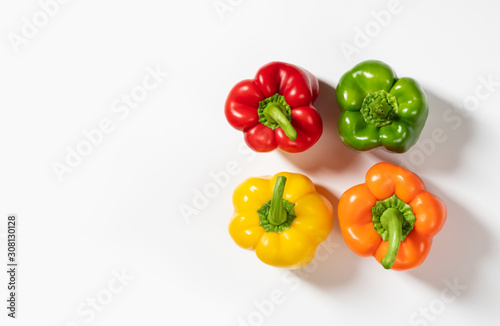 Colored bell peppers on white background. Green, yellow, orange and red pepper. Food concept.