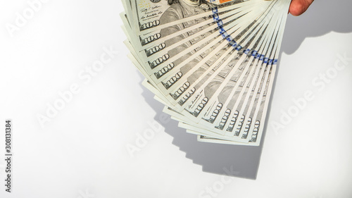 100 dollar banknote in hand shadow falling on white background