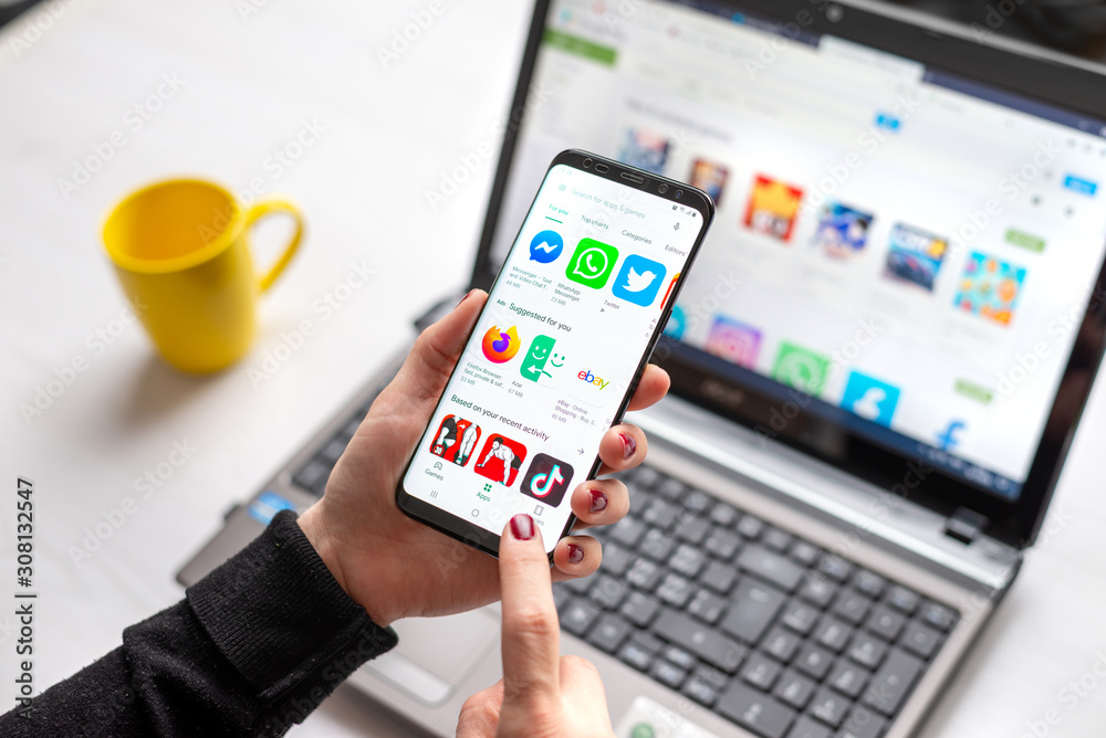 Sarajevo, Bosnia and Herzegovina - December 7, 2019: Girl installs apps from Google Play on android mobile phone close-up