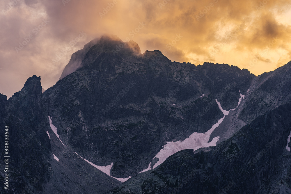 Dramatic sunset over a moutain alpine like landscape of High Tatras, Slovakia. Rugged rocky mountains during spectacular sunset or sunrise. High peaks of Tatra mountains.