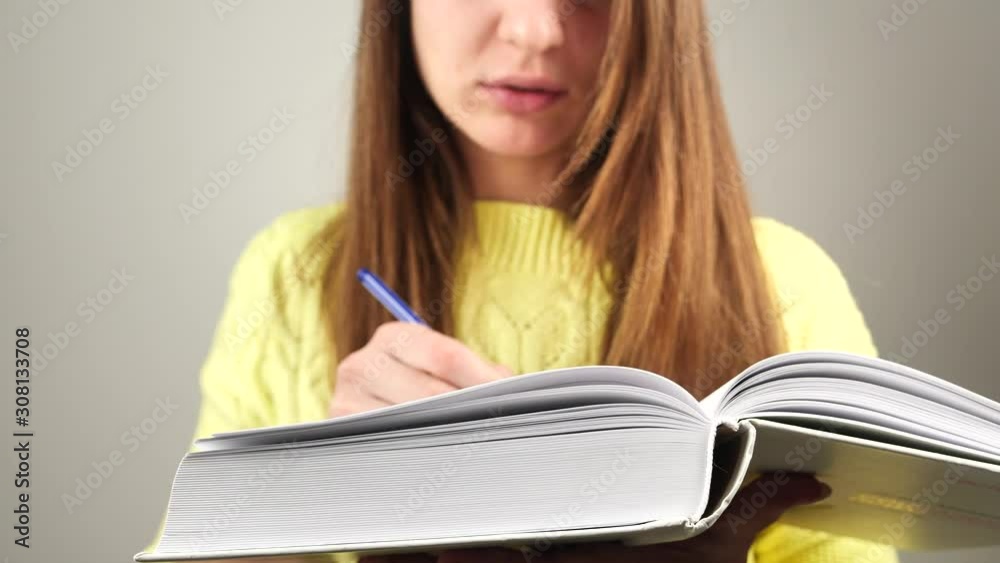 Young charming female student reading book trying to remember text 4k Young charming female student reading book trying to remember text 4k