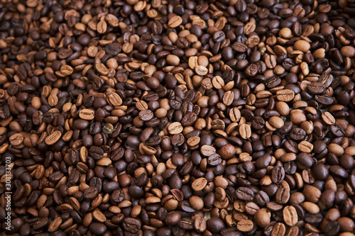 A lot of roasted dark brown and light brown coffee beans as background