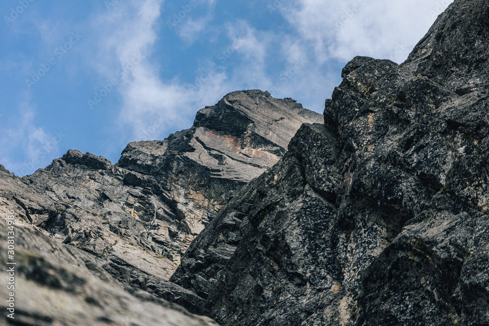 Detail of a mountain rock face, background or wallpaper picture of big wall rock climb, clouds and mist, stone and rock surface. Huge rock wall of granite in High Tatras, Slovakia.