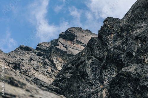 Detail of a mountain rock face, background or wallpaper picture of big wall rock climb, clouds and mist, stone and rock surface. Huge rock wall of granite in High Tatras, Slovakia. © Ondra