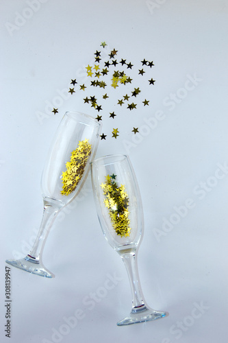 It`s party time! Isolated two champagne glasses with glittering gold ornaments on a white background.