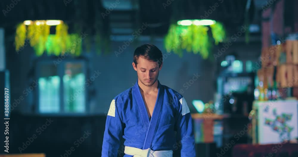 Taekwondo man preparing for battle with the enemy, tuned. Young taekwondo player looks up, a serious look. Portrait view.