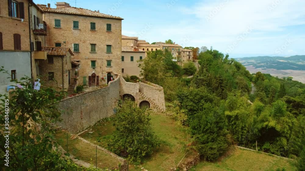 Close-up of the medieval golden architecture of Volterra, a mountaintop town in Tuscany, Italy, contrasting with green scenery Close-up of the medieval golden architecture of Volterra, a mountaintop town in Tuscany, Italy, contrasting with green scenery