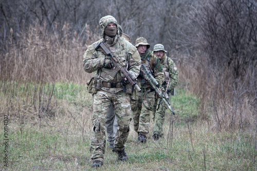 Army commandos tactical group on march in woods