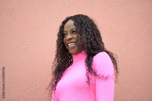 Portrait of a happy afro-style black girl with long black curly hair smiling and looking to the left