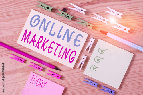 Conceptual hand writing showing Online Marketing. Concept meaning promoting products and services through the internet Colored crumpled papers wooden floor background clothespin