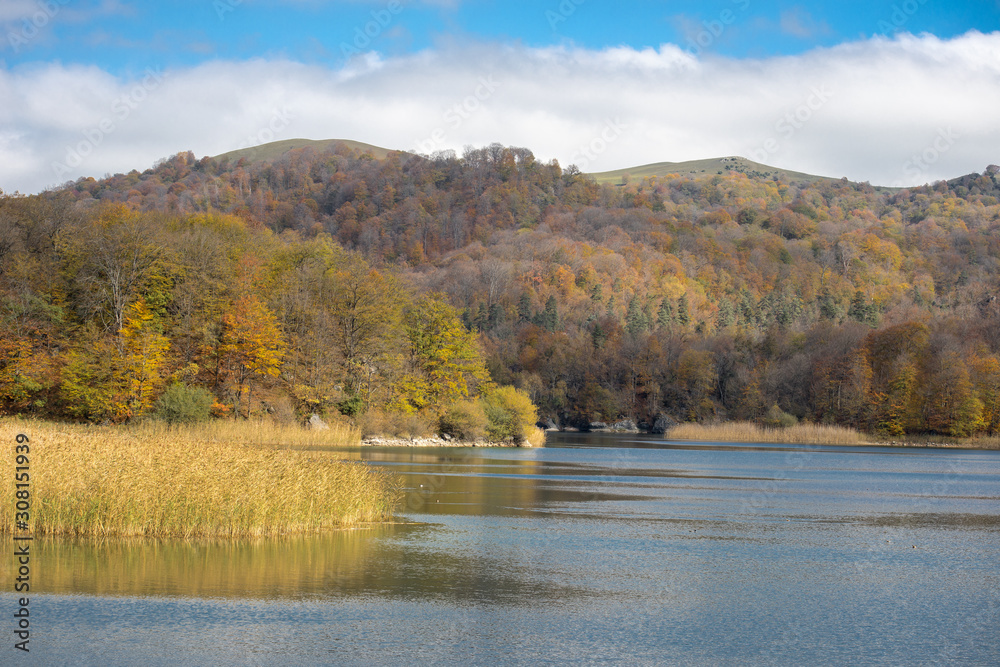 A calm evening landscape with lake and mountains. Amazing view of the Goy-Gol (Blue Lake) Lake among colorful fall forest at Ganja, Azerbaijan. A calm evening landscape with lake and mountains. Amazing view of the Goy-Gol (Blue Lake) Lake among colorful fall forest at Ganja, Azerbaijan.