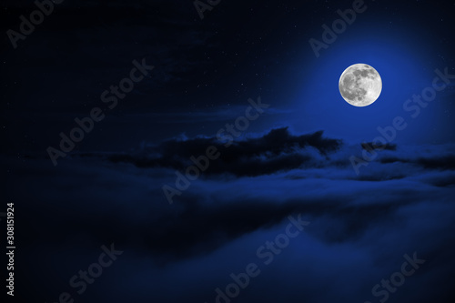 Shone circle of the moon in darkness on a background of the star sky and clouds