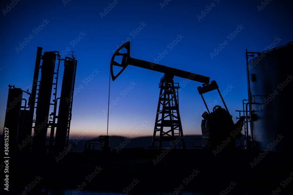 Creative artwork decoration. Oil pump and oil refining factory at sunset. Energy industrial concept. Selective focus. Creative artwork decoration. Oil pump and oil refining factory at sunset. Energy industrial concept. Selective focus.