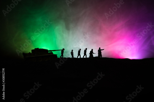 War Concept. Military silhouettes fighting scene on war fog sky background  World War German Tanks Silhouettes Below Cloudy Skyline At night. Attack scene. Armored vehicles and infantry.