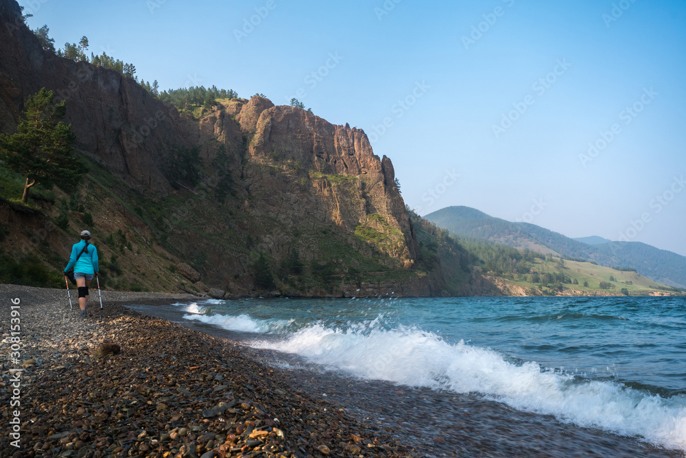 Fototapeta premium A girl walks along the shore of Lake Baikal