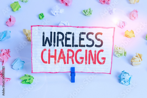 Handwriting text writing Wireless Charging. Conceptual photo methods of charging batteries without the use of cables Colored crumpled papers empty reminder white floor background clothespin © Artur