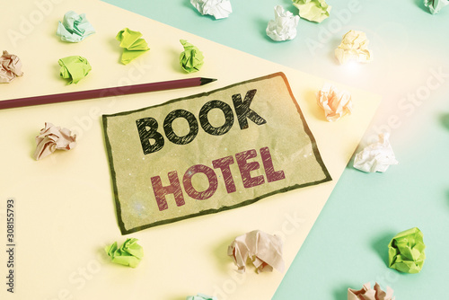 Handwriting text writing Book Hotel. Conceptual photo an arrangement you make to have a hotel room or accommodation Colored crumpled papers empty reminder blue yellow background clothespin