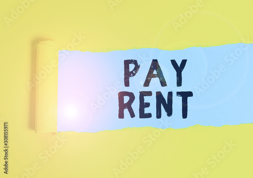 Writing note showing Pay Rent. Business concept for To pay money in exchange for the use of someone else s is property Cardboard which is torn placed above a wooden classic table photo