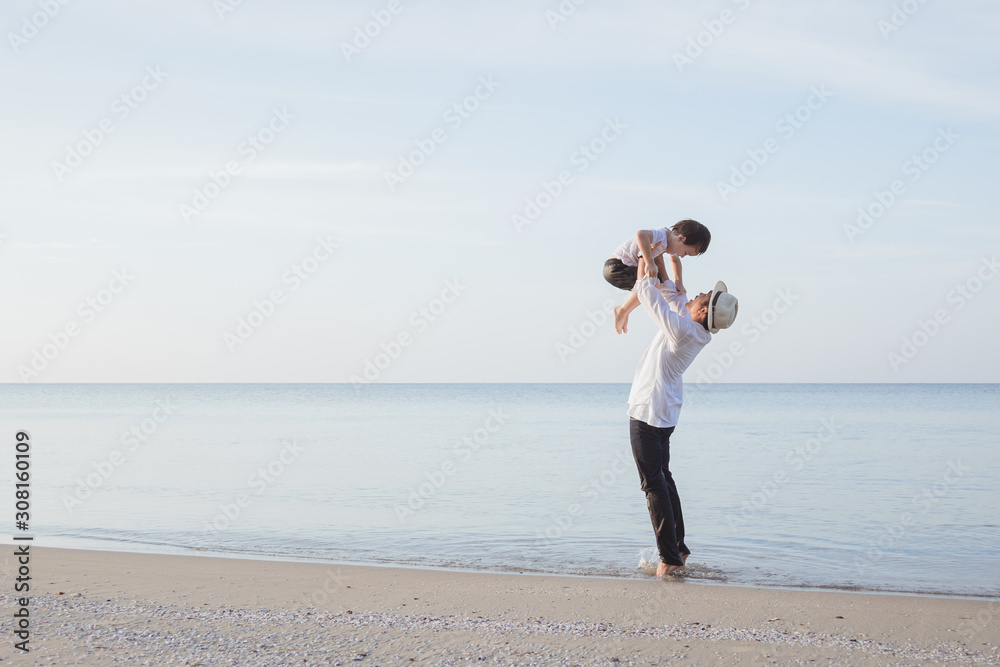 Happy family travel on beach in holiday, Father and son walk with fun along edge of  on a tropical beach in the morning.