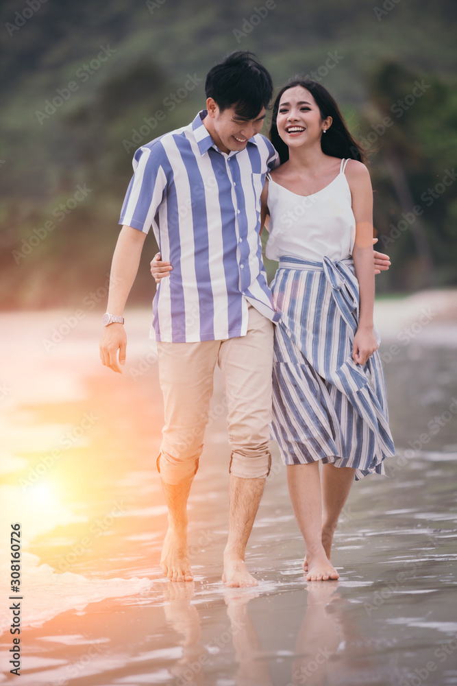 Happy romantic couples strolling and watching the beautiful sunset on the evening beach. Happy romantic couples strolling and watching the beautiful sunset on the evening beach.