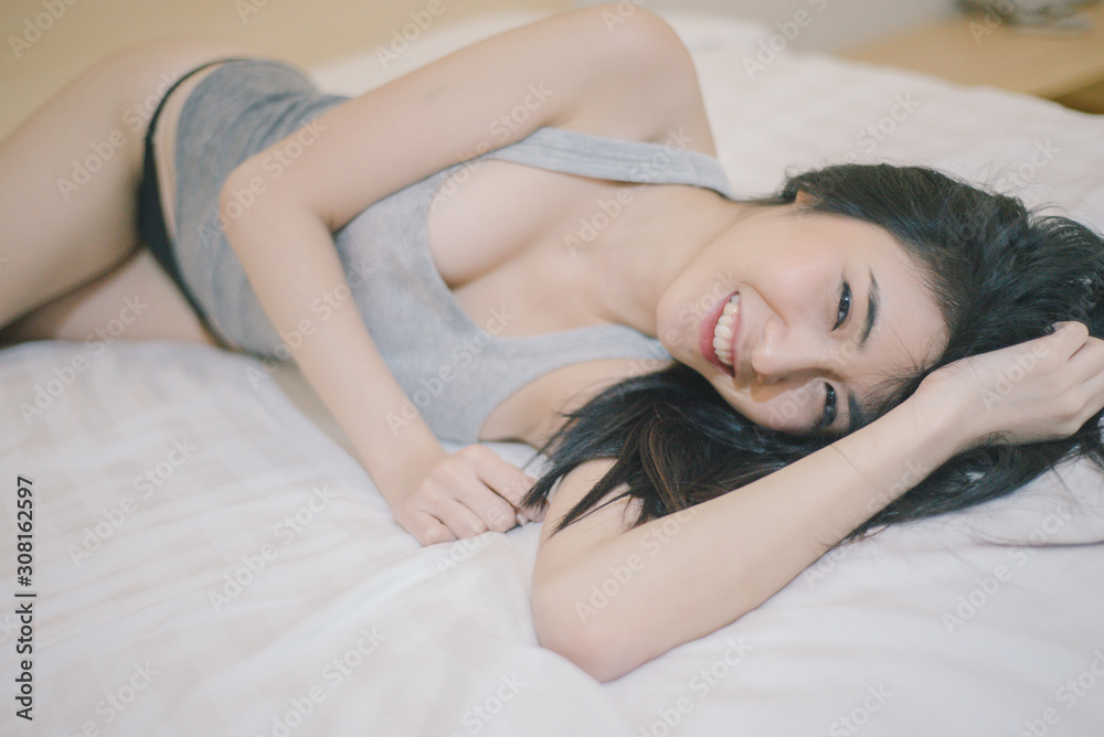 Portrait of a sexy woman with long hair wearing black underwear and a gray tank top - obrazy, fototapety, plakaty 