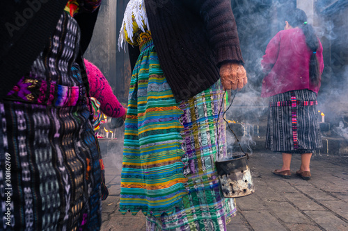 Las mujeres mayas están rezando y echando  incienso afuera de la Iglesia de Santo Tomas Chichicastenango Guatemala. photo